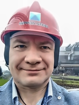 Alexey Baranov wearing a hard hat during a benchmarking visit to an industrial site